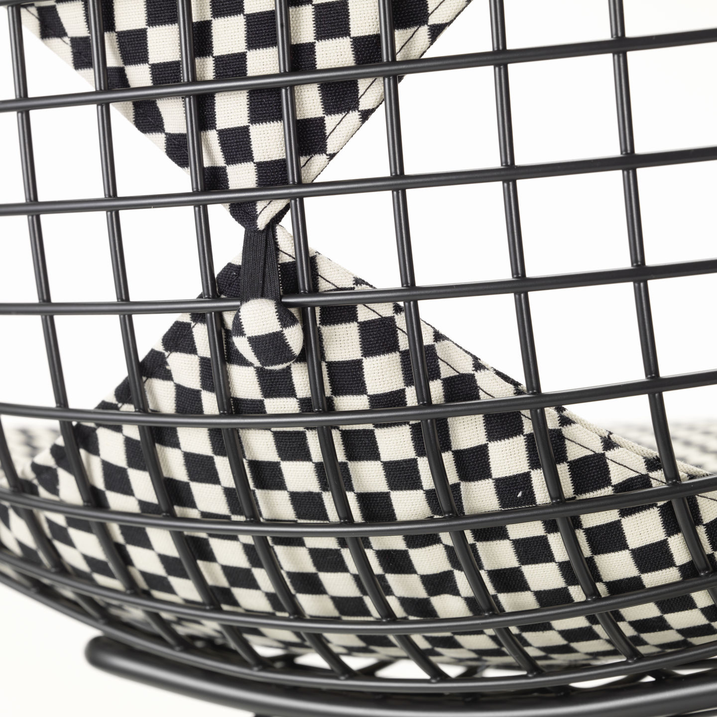 Detailaufnahme des DKW-2 Wire Chair Stuhls von Vitra mit schwarz-weiß kariertem Sitz- und Rückenpolster.