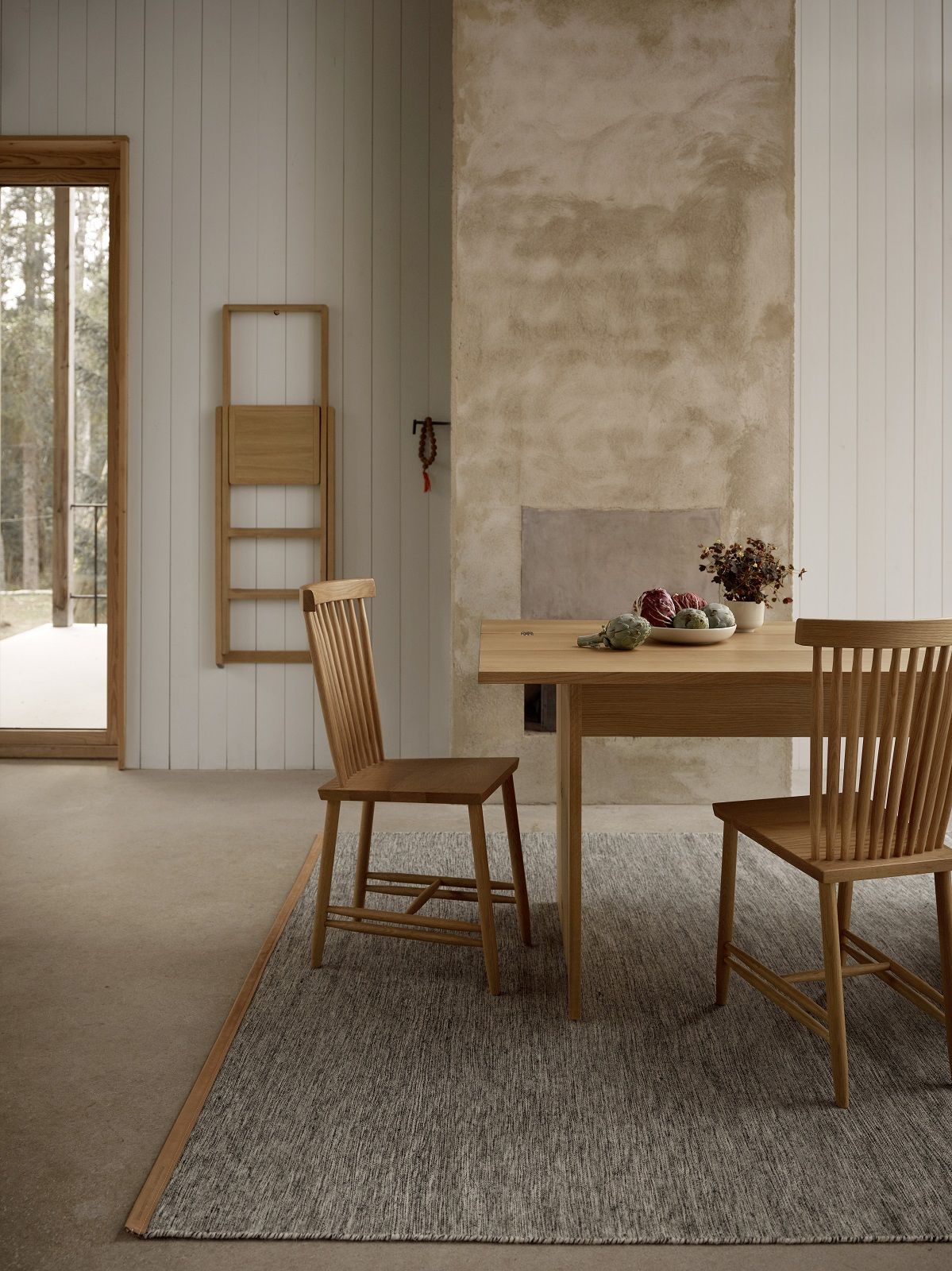 Björk Teppich von Design House Stockholm unter Esstisch mit Stühlen in hellem Raum.