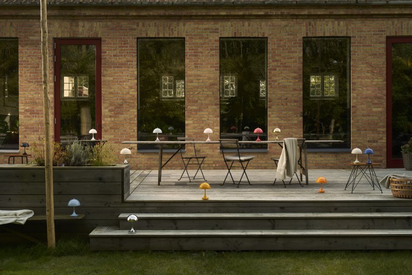 Panthella Portable V3 LED-Tischleuchten von Louis Poulsen in verschiedenen Farben auf einer Terrasse.