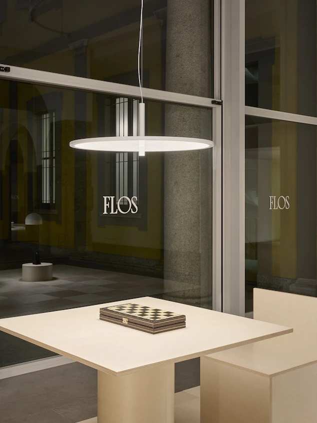 My Disc Hängeleuchte von Flos, moderne LED-Pendelleuchte in Weiß über einem Tisch mit Schachbrett.