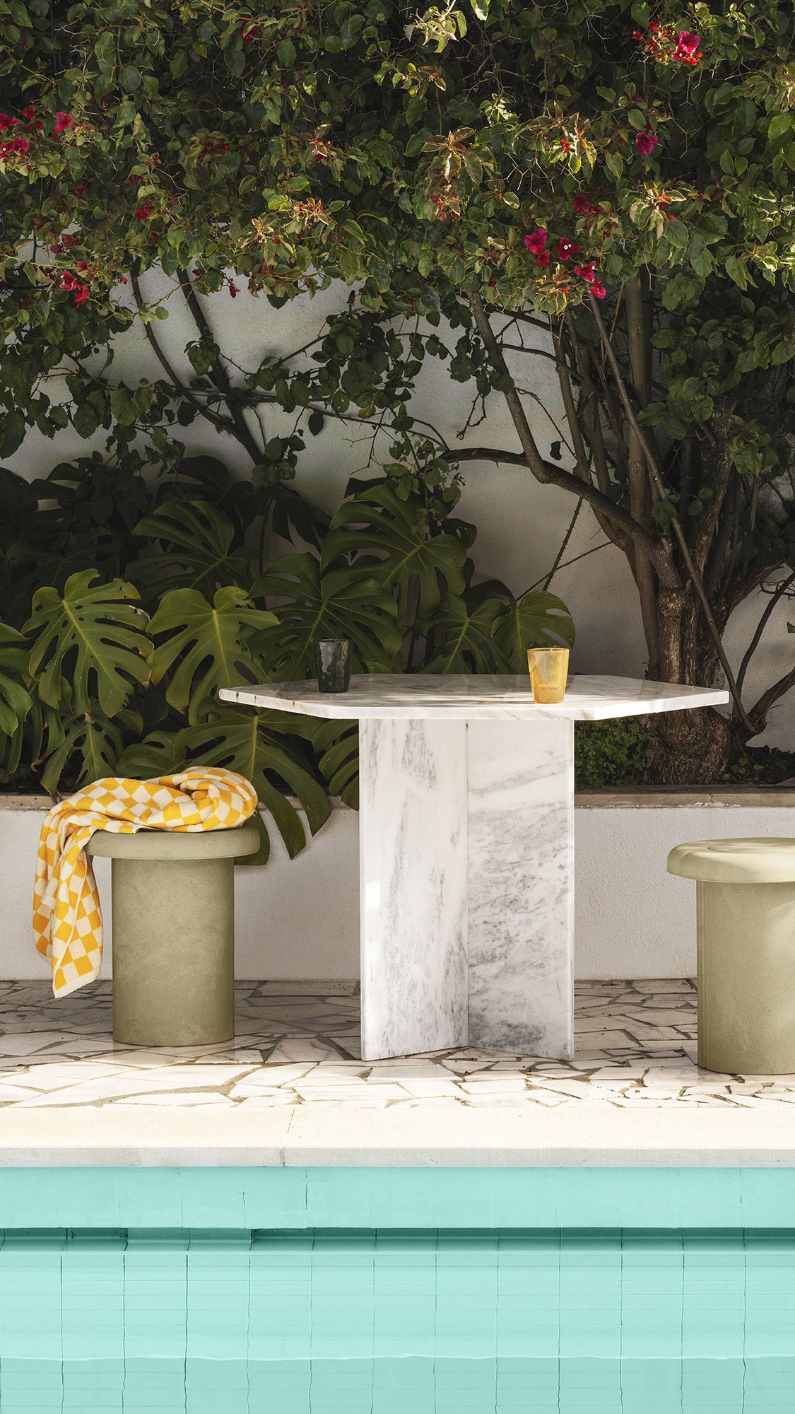 Alder Stool Hocker von Mater für den Innen- und Außenbereich, mit gelbem Tuch dekoriert.