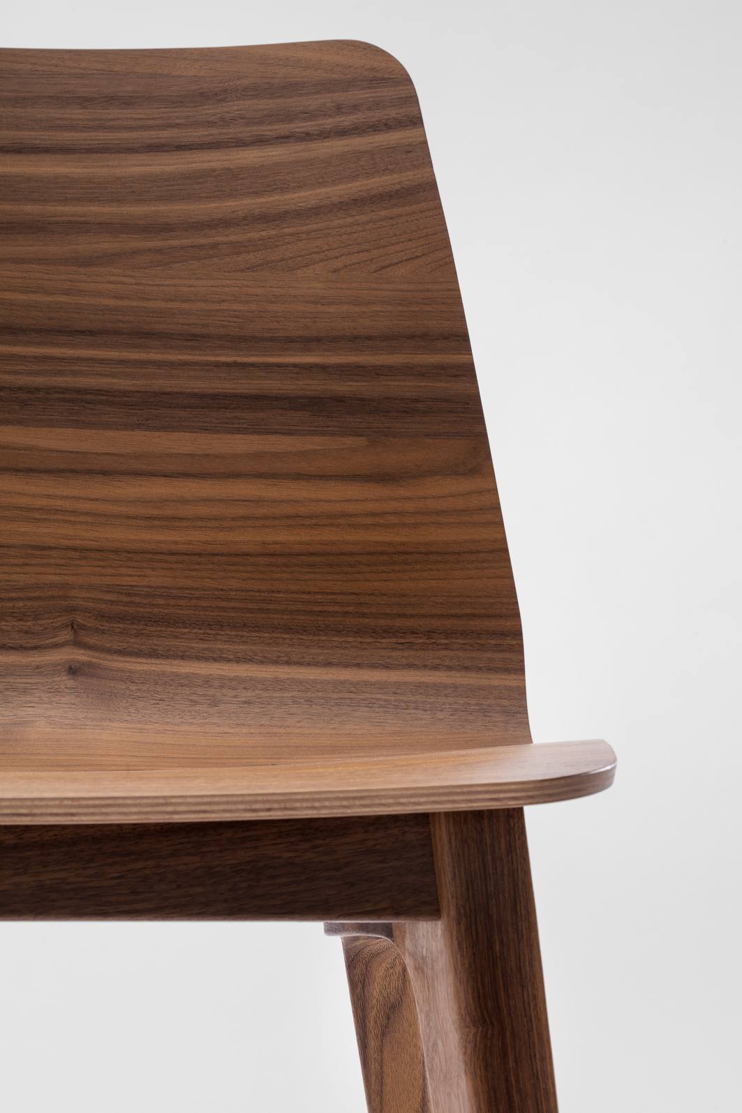 Detailaufnahme des Morph Plus Holzstuhls von Zeitraum, gefertigt aus edlem Nussbaumholz, minimalistisches Design.
