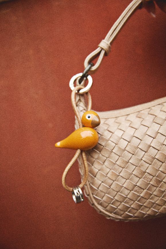 Vogel rood/oranje sleutelhanger van zilverkleurig metaal met natuurlijk leer – Kay Bojesen