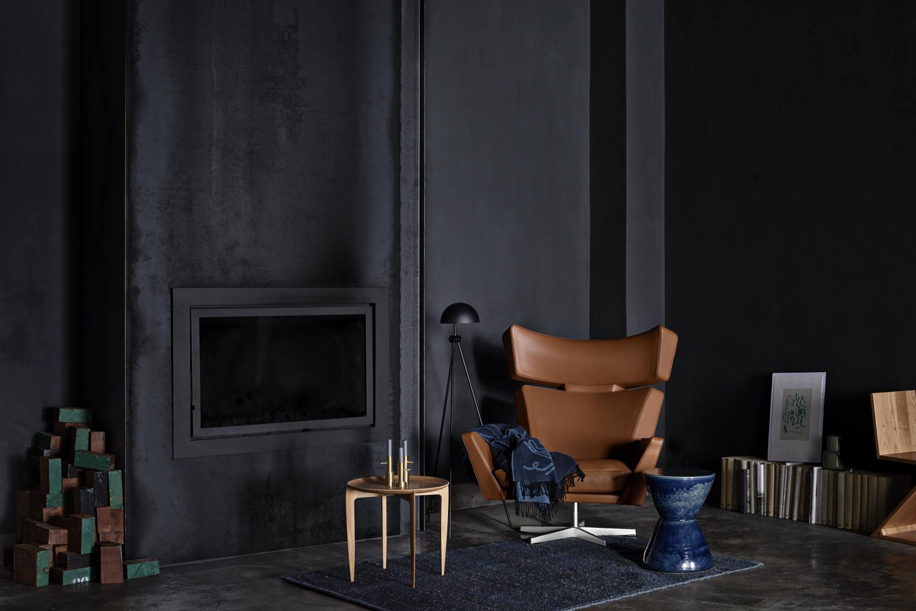 Oksen Sessel von Fritz Hansen in braunem Leder mit Decke in dunklem Wohnzimmer.