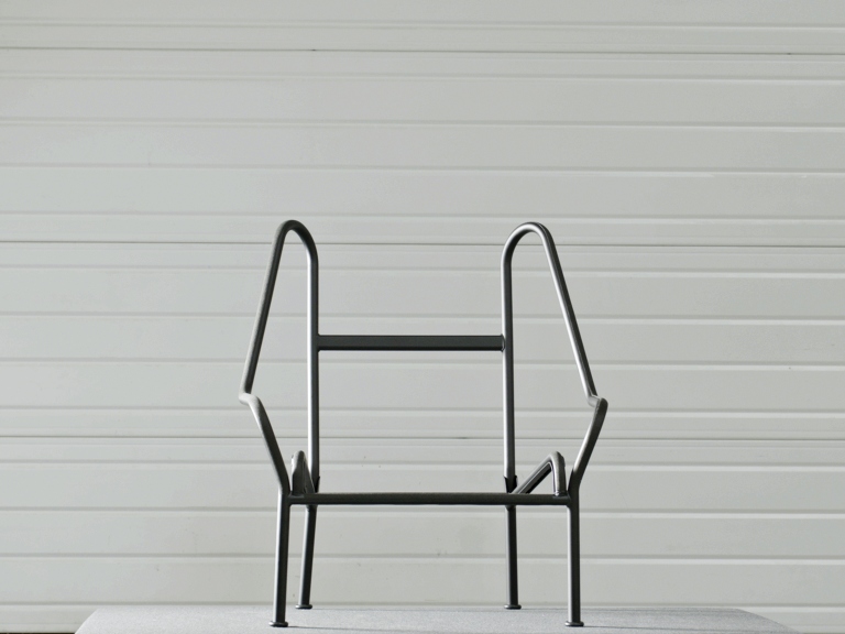 Minimalistischer 02 Lounge Chair Sessel von Hay mit schwarzem Metallgestell vor weißer Wand.