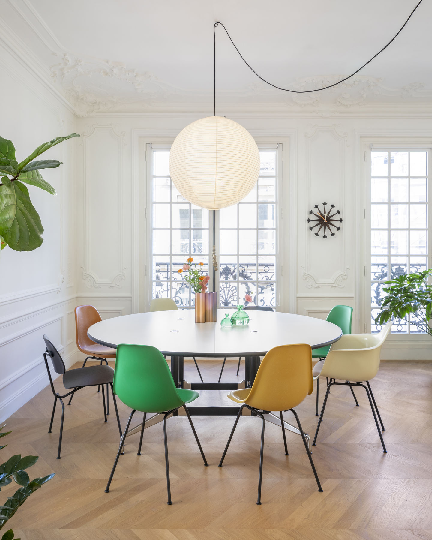 Eames Fiberglass Chair DSX Stühle von Vitra in verschiedenen Farben um einen runden Tisch.