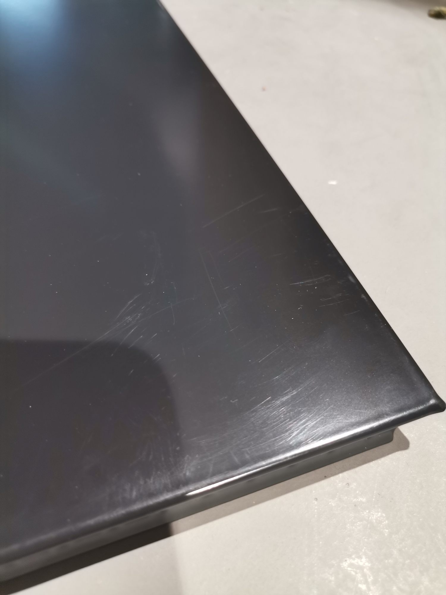 Detailaufnahme einer schwarzen USM Haller Tischplatte mit Kratzern, ein Mängelexemplar für Ersatzteile.