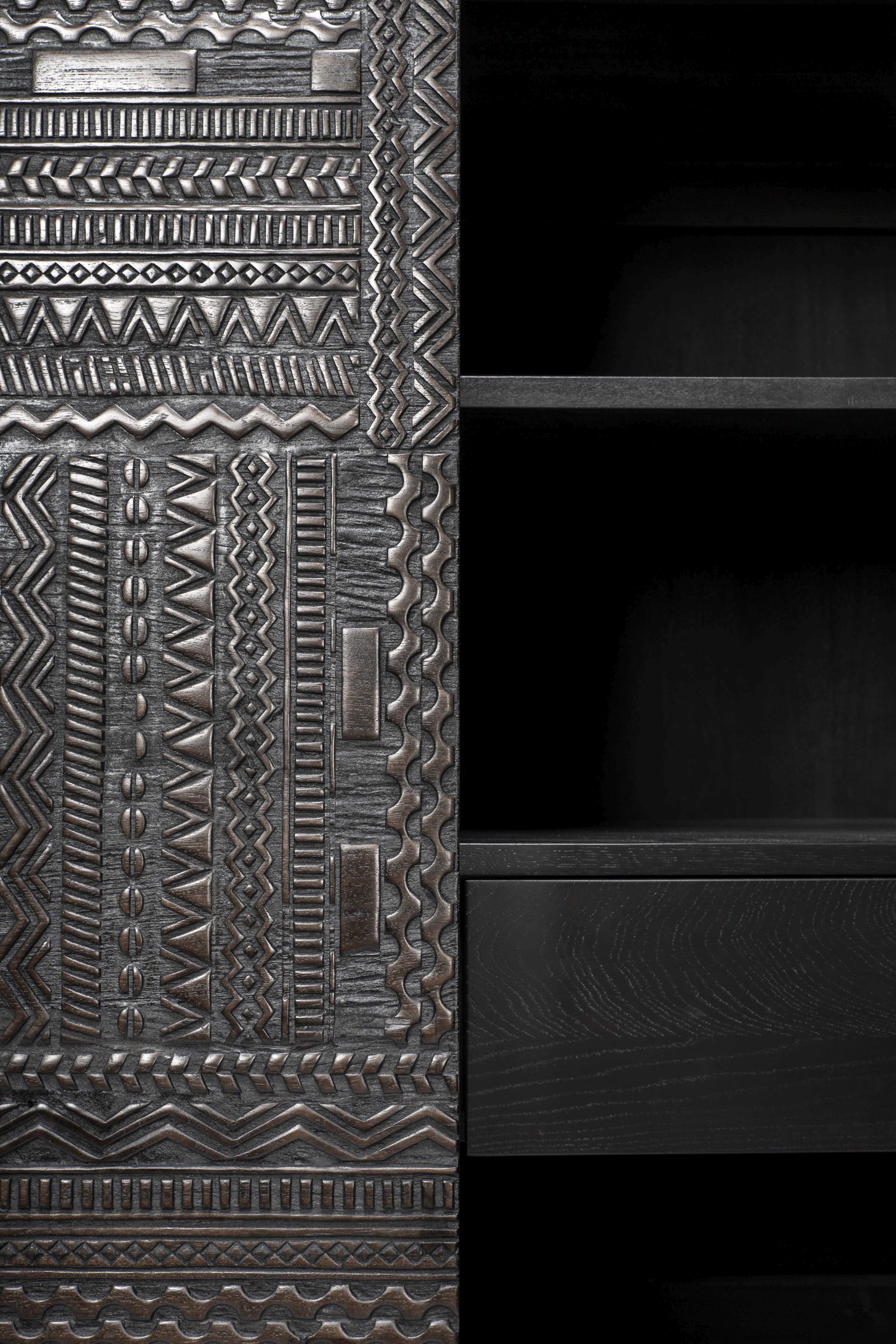 Detailaufnahme des Ethnicraft Tabwa Schrankes aus Teakholz mit ethnischen Mustern und Regalen.