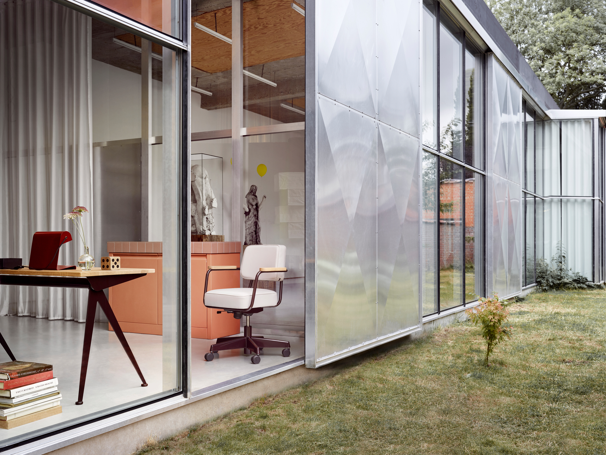 Vitra Compas Direction Schreibtisch im modernen Büro mit Design-Stuhl und Blick in den Garten.