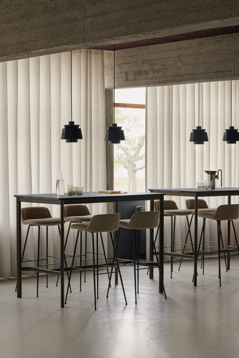 AndTradition Drip High Table Stehtisch mit Barhockern und schwarzen Pendelleuchten in modernem Ambiente.