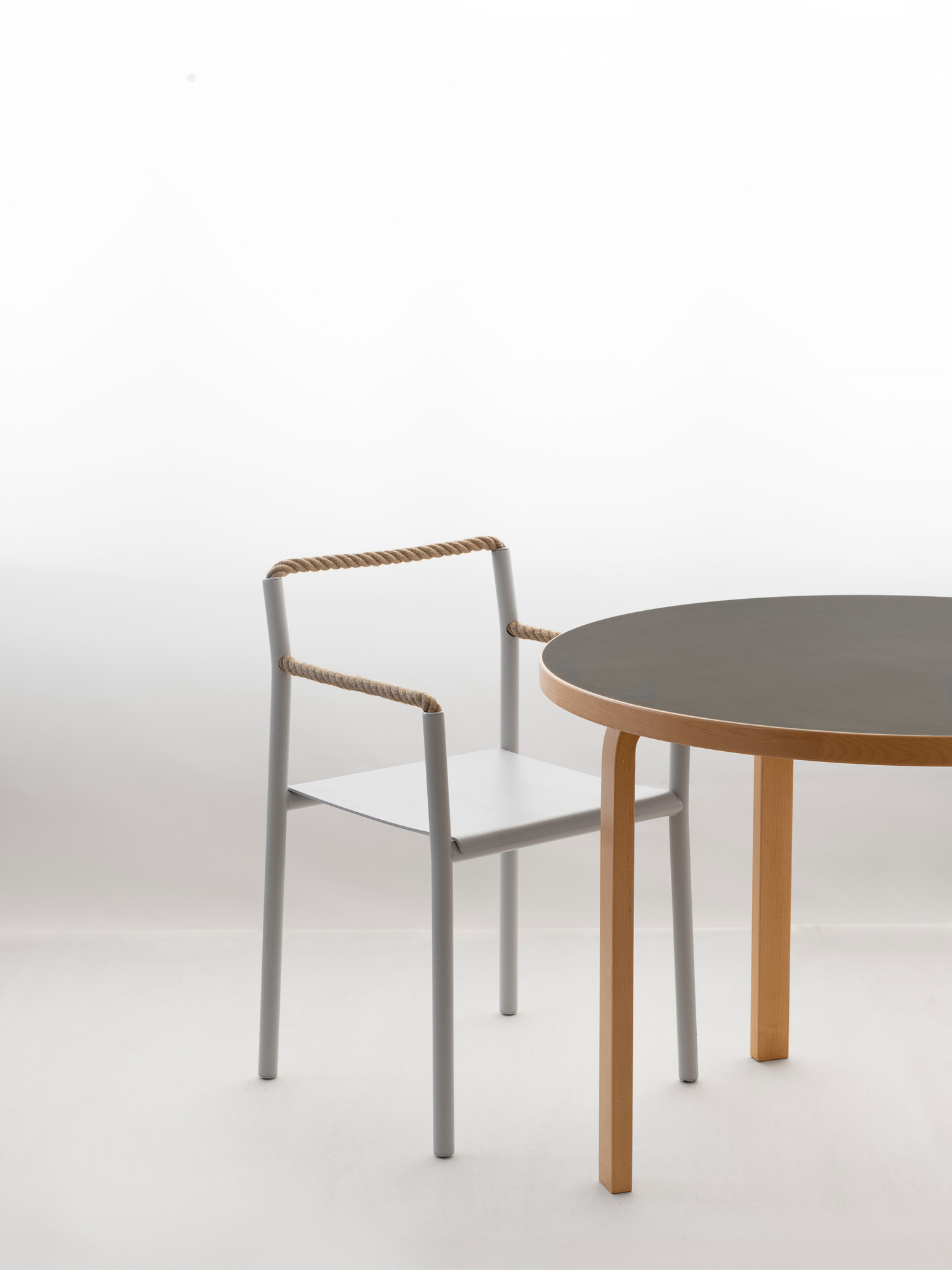 Artek Rope Chair: Moderner Stuhl mit Seildetails und minimalistischem Design neben einem Holztisch.