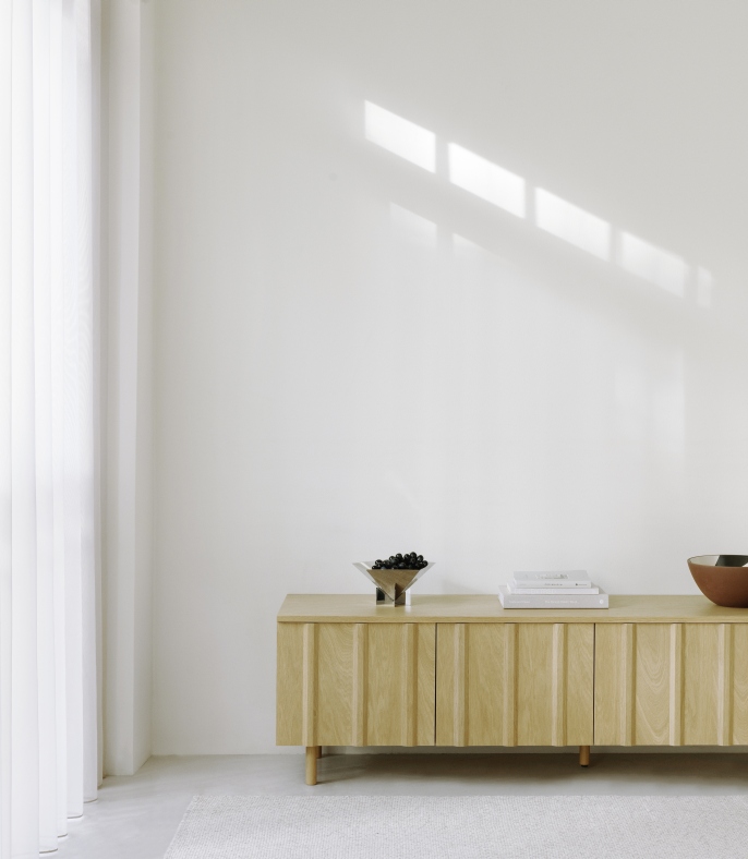 Fem Schale von Normann Copenhagen aus Edelstahl auf einem Sideboard mit Deko-Objekten in minimalistischem Interieur.