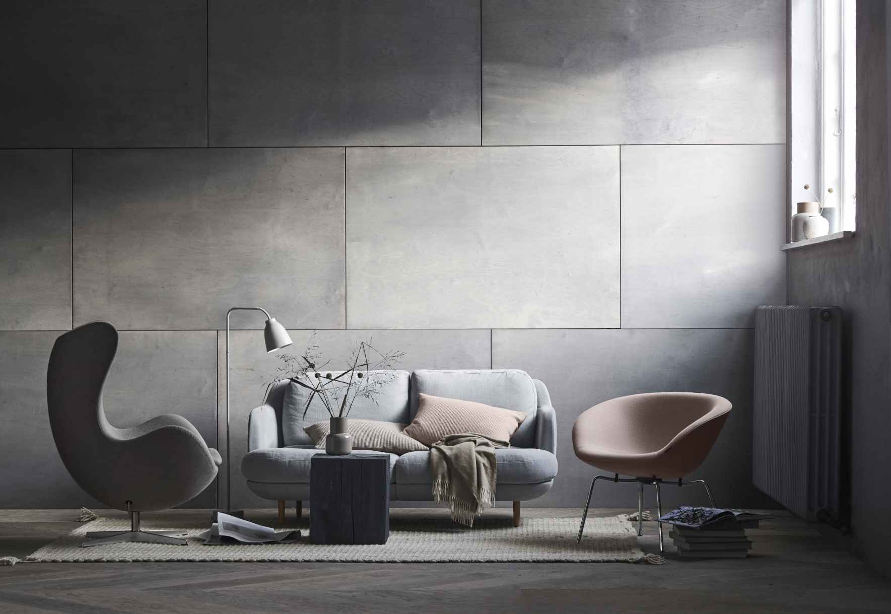 Wohnzimmer-Szene mit grauem Lune Sofa von Fritz Hansen, Sessel und Design-Stuhl.