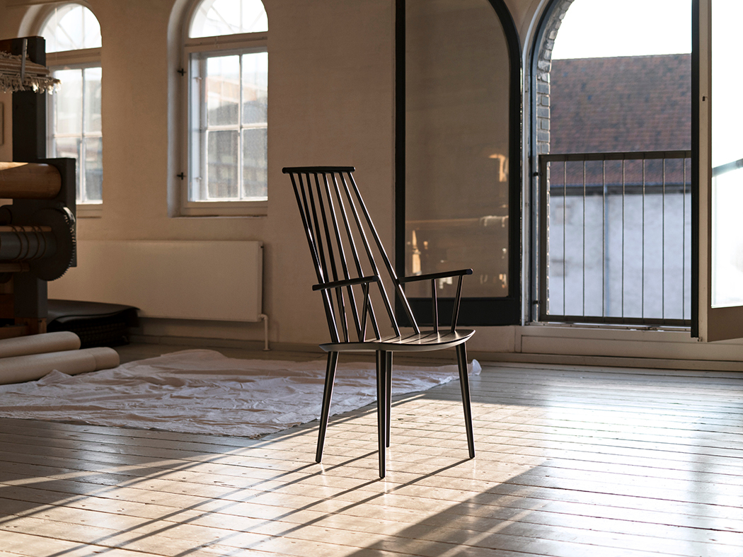 Schwarzer J110 Chair Stuhl von Hay, Holzstuhl mit Armlehnen im hellen Raum. Designklassiker.