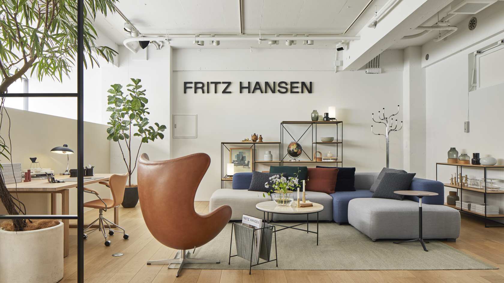 Heller Wohnraum mit Fritz Hansen Möbeln: Couch, Sessel, Regale und Planner Coffee Table Couchtisch.