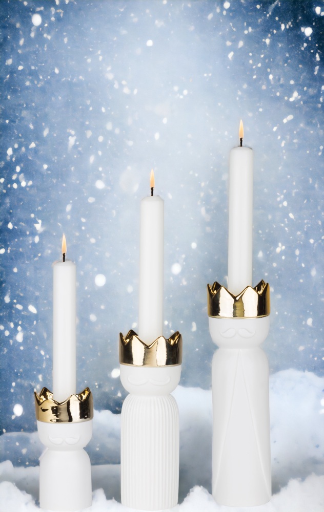 Königslicht 3er Set Räder: Drei weiße Kerzenständer mit goldener Krone und brennenden Kerzen.