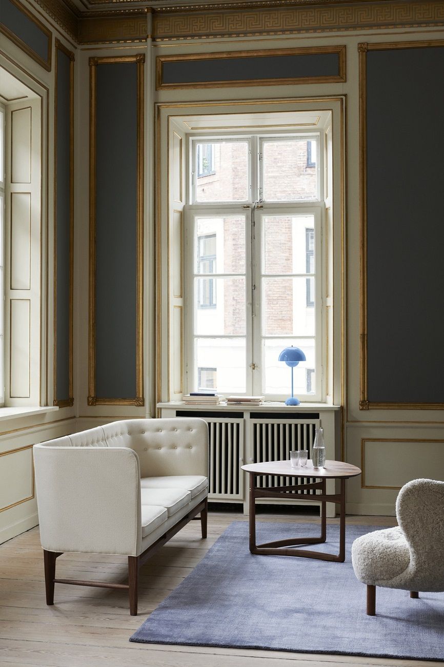 AndTradition Drop Leaf HM5 Beistelltisch aus Holz im klassischen Wohnzimmer mit Sofa und Teppich.
