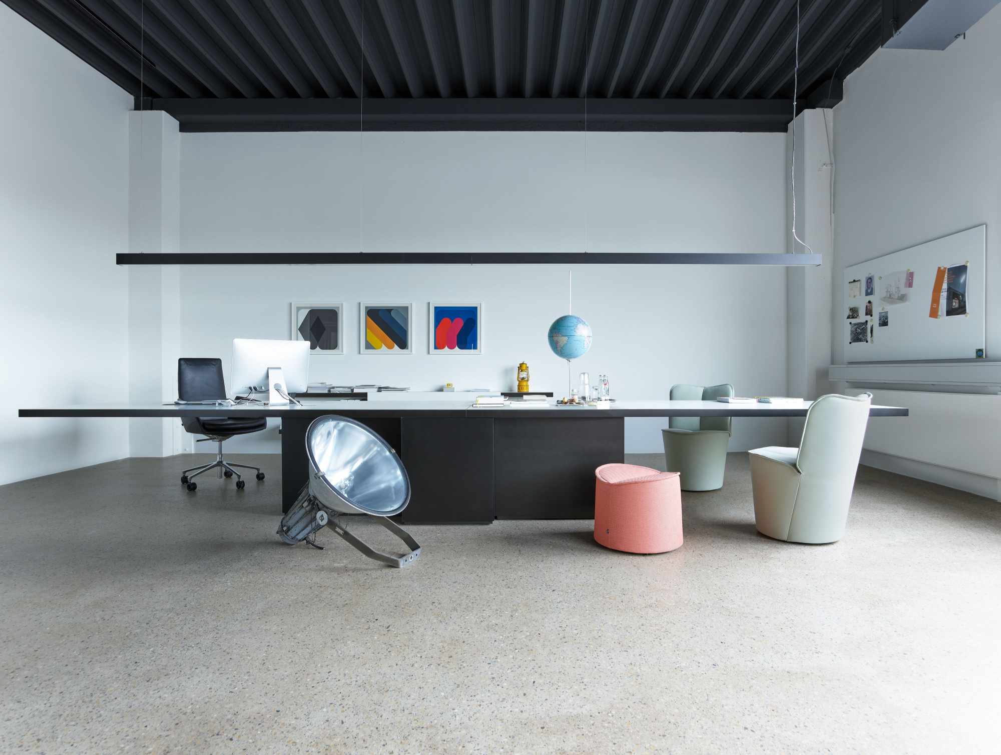 Büro mit Cor Sessel, Schreibtisch, Lampe und Dekoration. Modernes Interior Design.