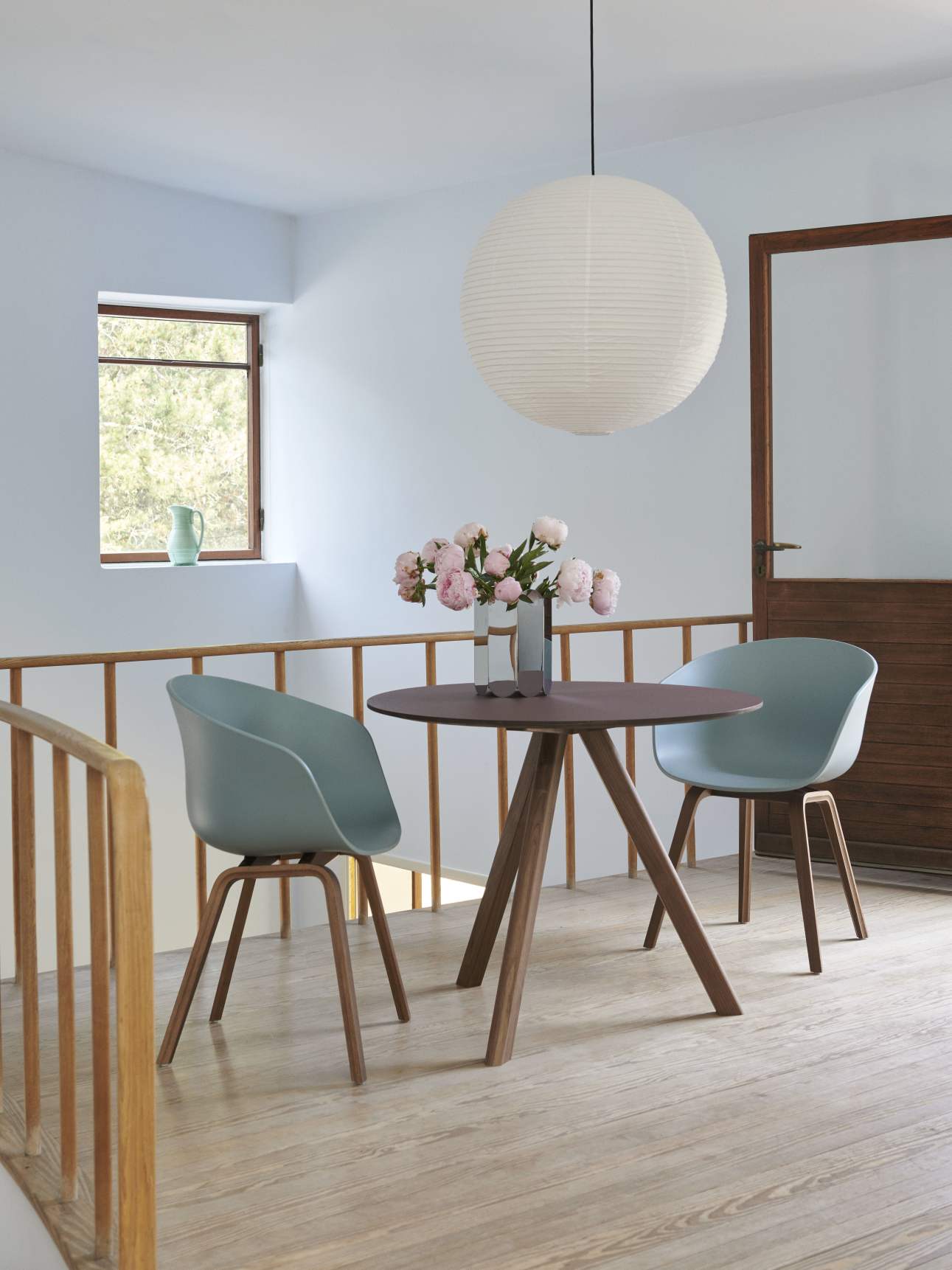 Runder Copenhague Table CPH 20 Tisch von Hay mit zwei Stühlen und Blumenvase im Interieur.
