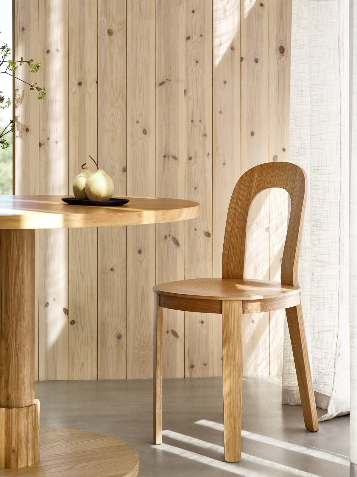 Olivia Chair von Design House Stockholm aus hellem Holz neben einem Esstisch.