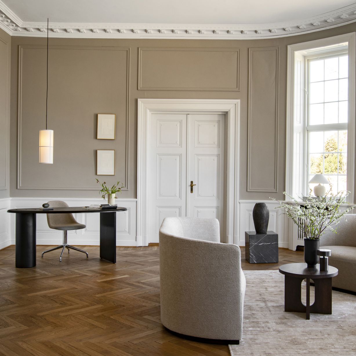 Helles Wohnzimmer mit Audo Hashira Pendelleuchte über modernem Schreibtisch. Skandinavisches Design für stilvolle Beleuchtung.