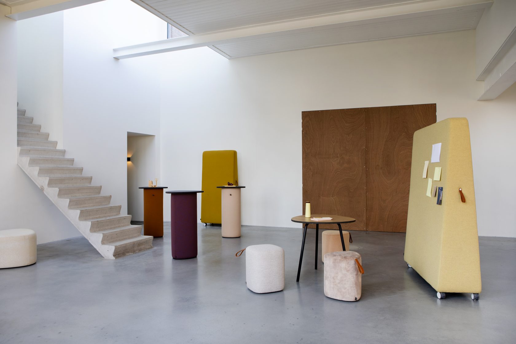 Innenraum mit Cascando Pully Pillar Stehtischen, Besprechungstisch, Hocker und mobiler Pinnwand.