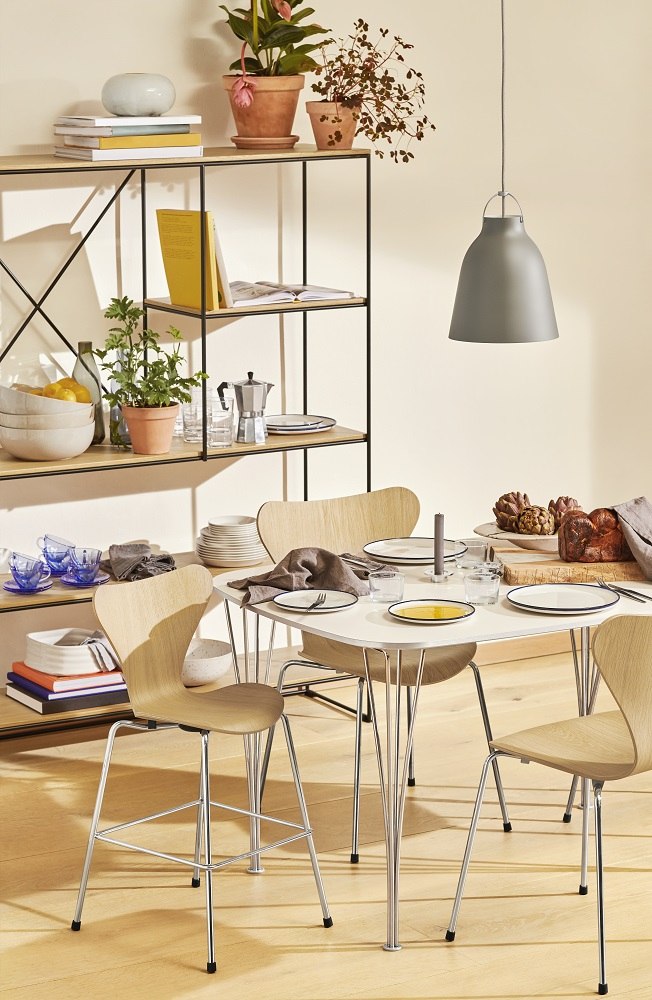 Esszimmer mit Fritz Hansen Series 7 Junior Chair Kinderhochstuhl aus hellem Holz und Chromgestell.