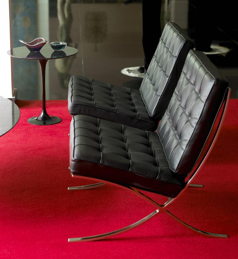 Barcelona Sessel von Knoll International mit schwarzem Leder und verchromtem Stahlgestell auf rotem Teppich.