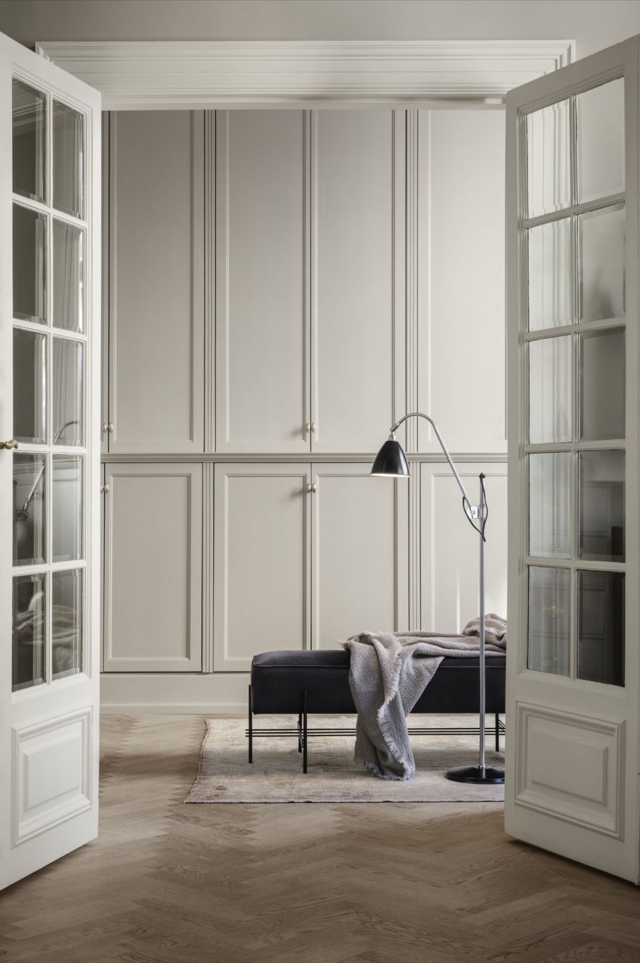 Bestlite BL3 Stehleuchte in Bone China/Chrom neben einer Bank in einem eleganten Interieur.