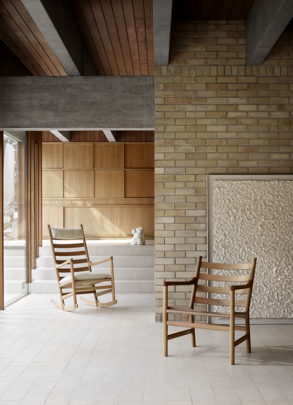 CH45 Schaukelstuhl von Carl Hansen, helles Holz, modernes Wohnzimmer mit Ziegelwand und Kunst.