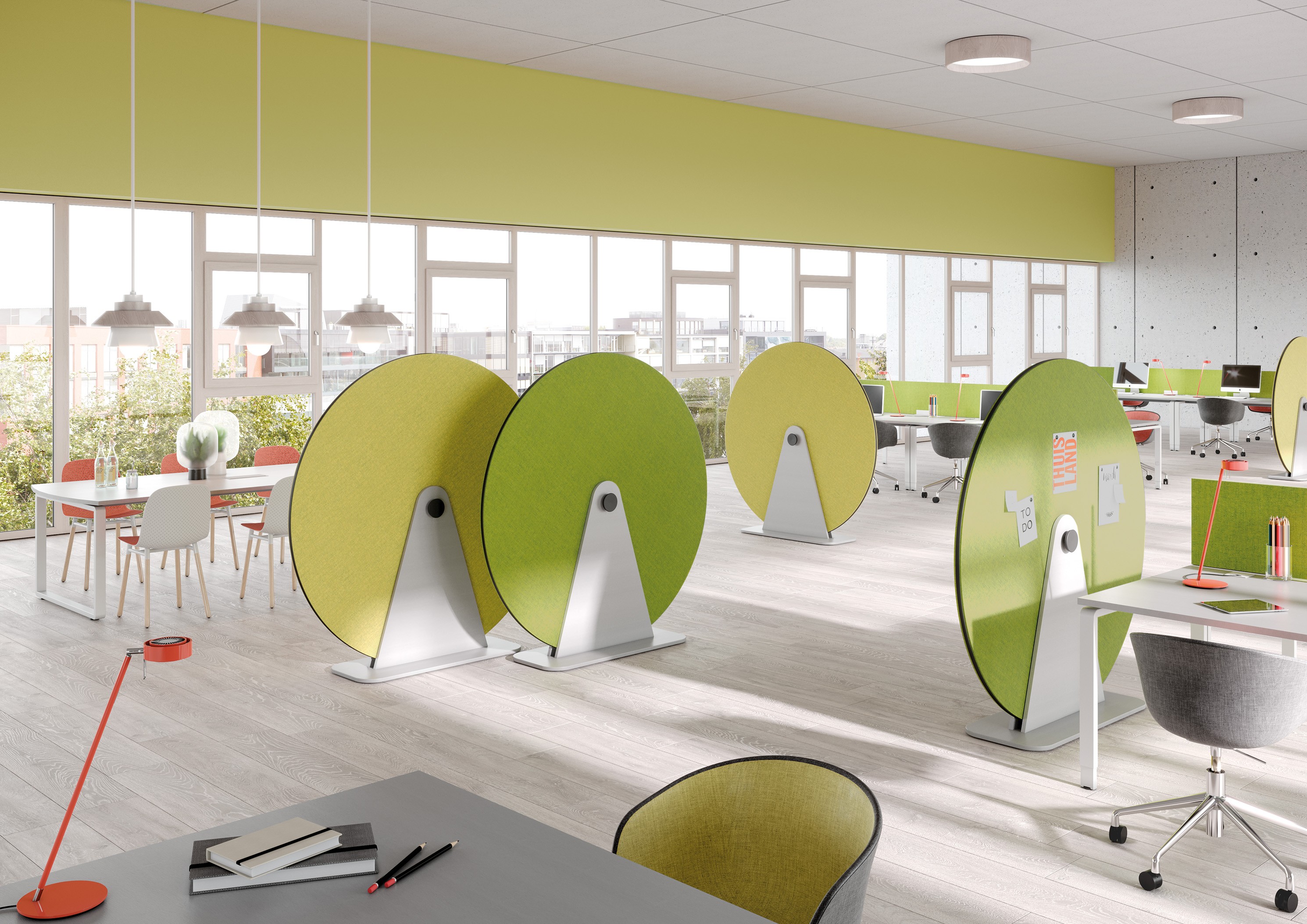 Büro mit modernen, runden Akustikpaneelen in Grün und Gelb zur Schallabsorption und als Raumteiler.