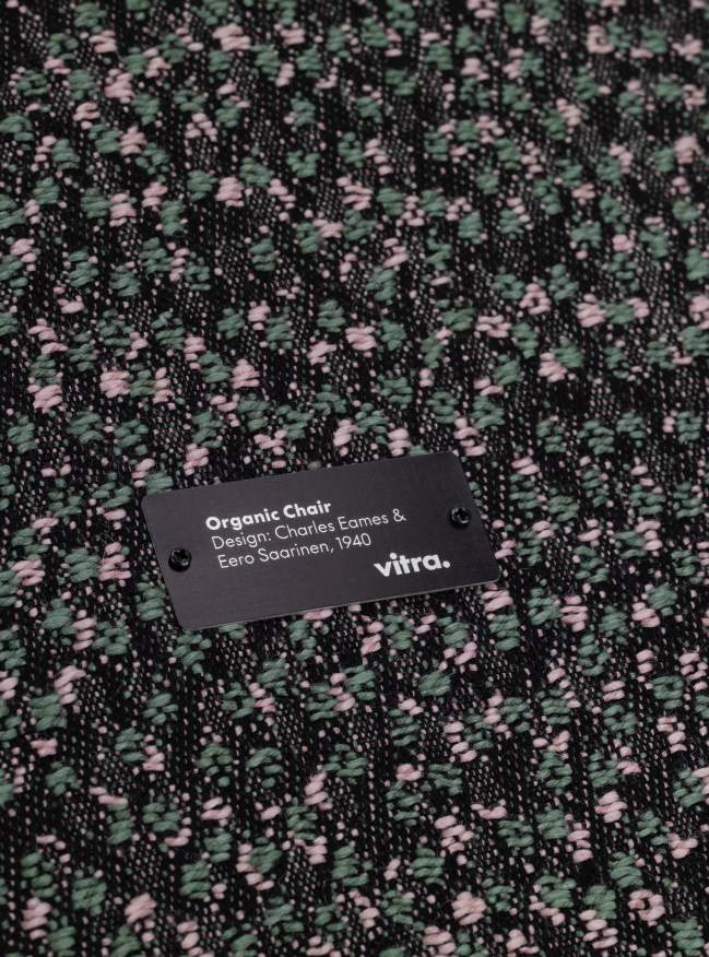 Detailaufnahme des Vitra Organic Conference Stuhls mit Kvadrat Ria 03 Stoffmuster in Grün und Rosa.