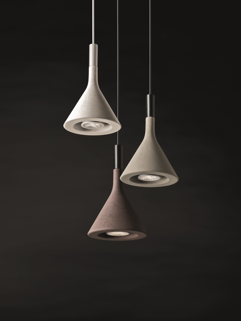 Aplomb Mini Pendelleuchte von Foscarini, drei moderne Beton-Hängelampen in Grau und Braun vor dunklem Hintergrund.