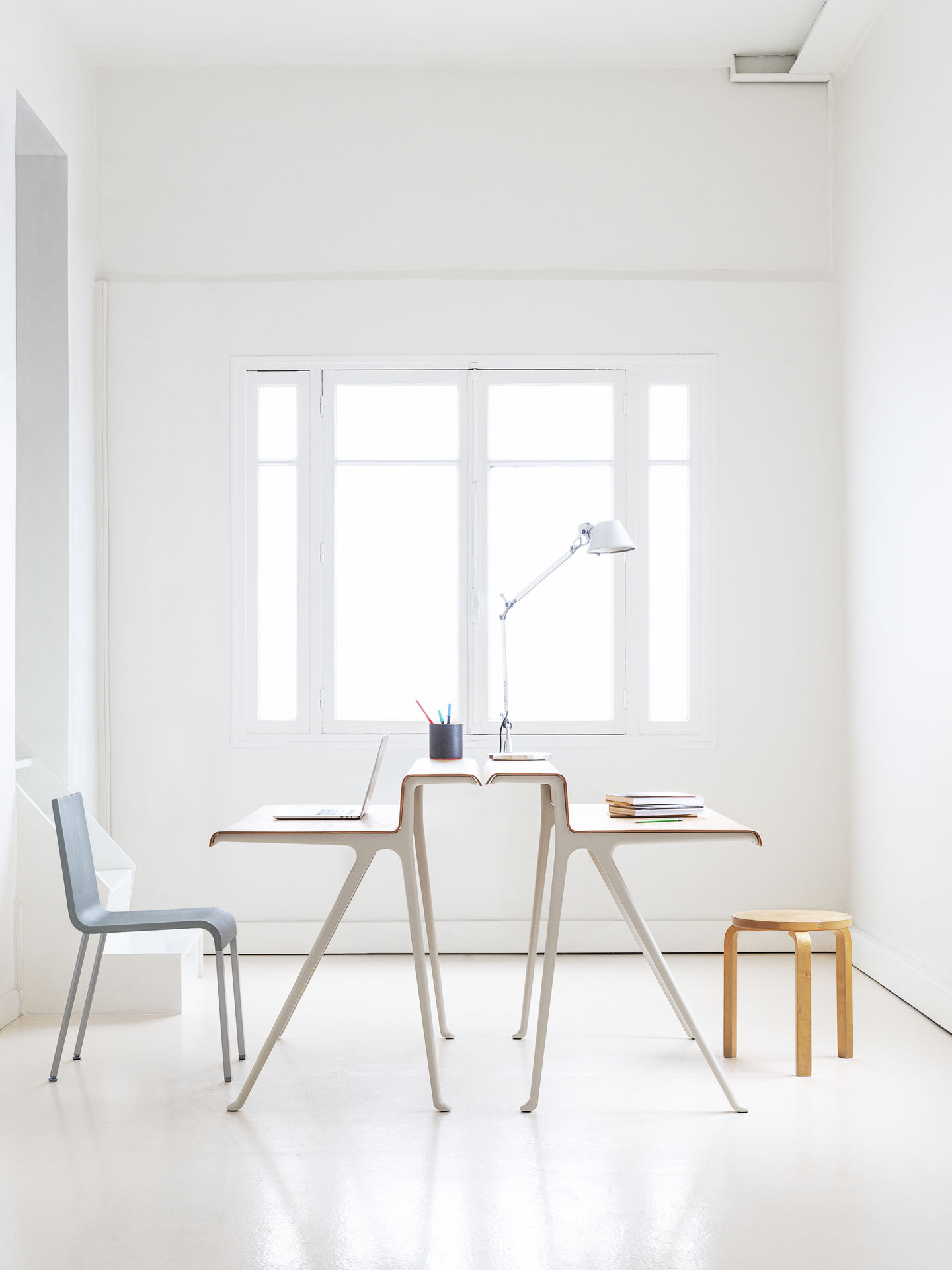 Heller Raum mit Vitra Courier Schreibtisch, Laptop, Lampe und Stuhl für modernes Homeoffice.