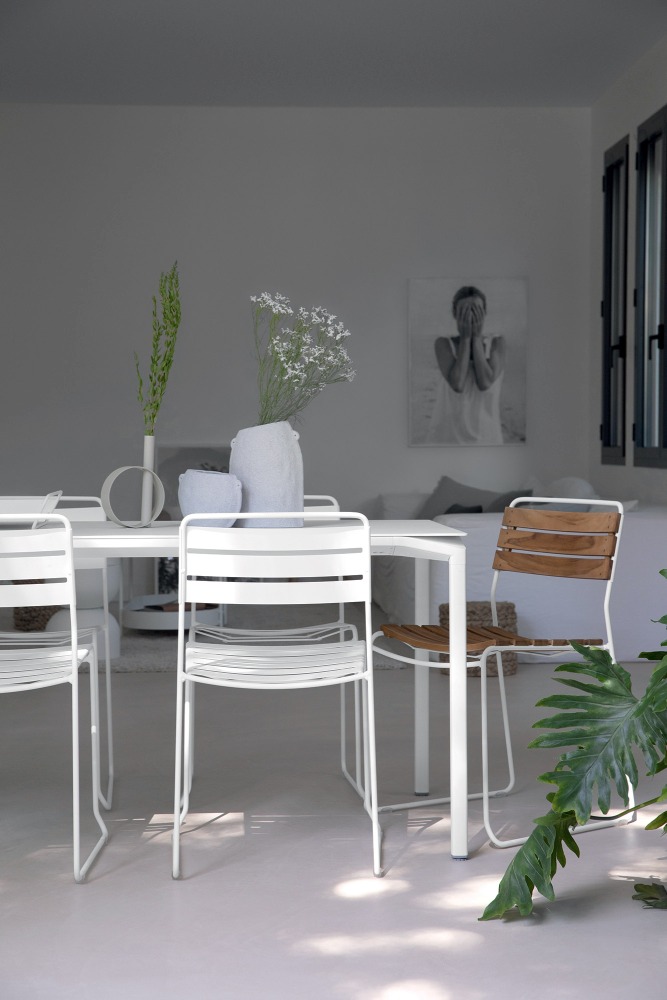 Weißer Surprising Teak Chair Stuhl von Fermob für den Außenbereich, kombiniert mit passendem Tisch.