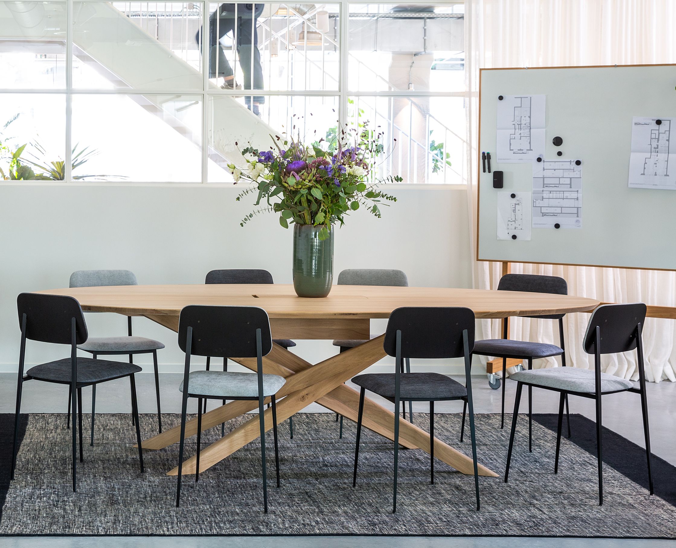 Ethnicraft Mikado Meetingtisch aus Eiche mit Stühlen in modernem Büro, ideal für Konferenzen.