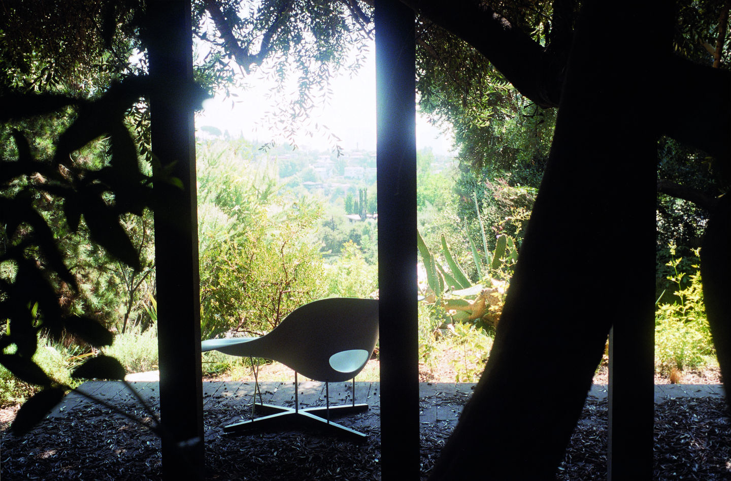 Vitra La Chaise Liege in Weiß vor Gartenkulisse, Designklassiker für stilvolles Wohnen und Entspannen.