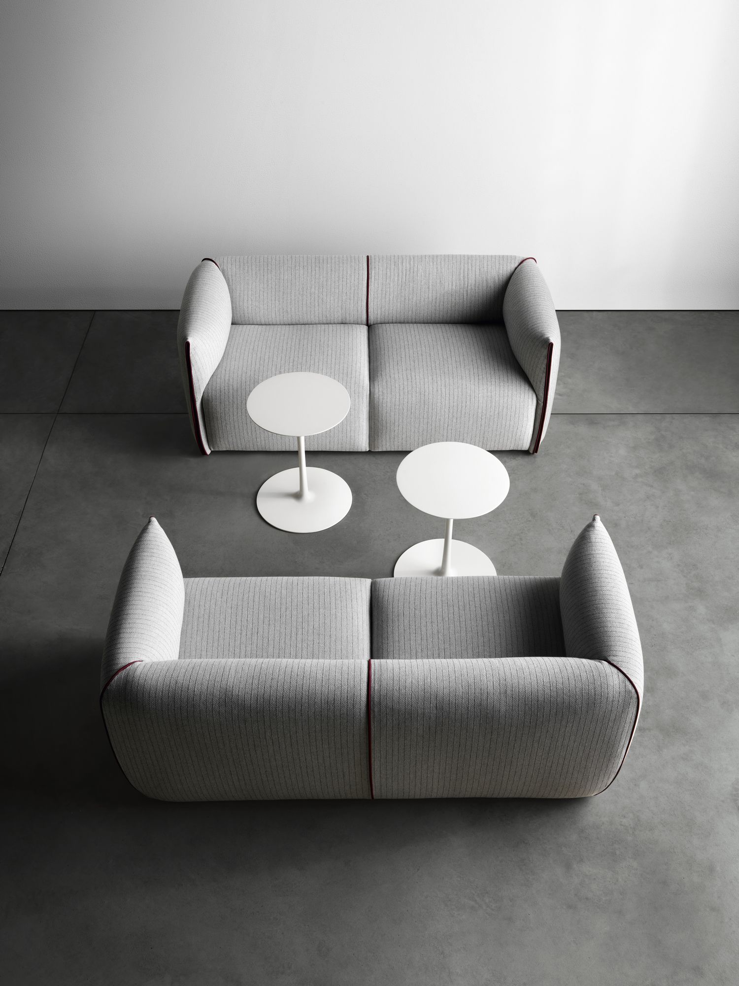 Zwei graue Sofas mit zwei weißen Flow Low Table Beistelltischen von MDF Italia im minimalistischen Ambiente.
