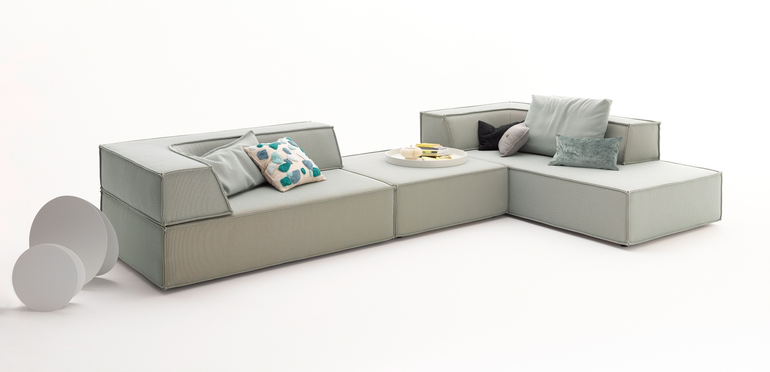 Helles modulares Cor Sofa mit Trio Rückkissen und Dekokissen auf weißem Hintergrund.