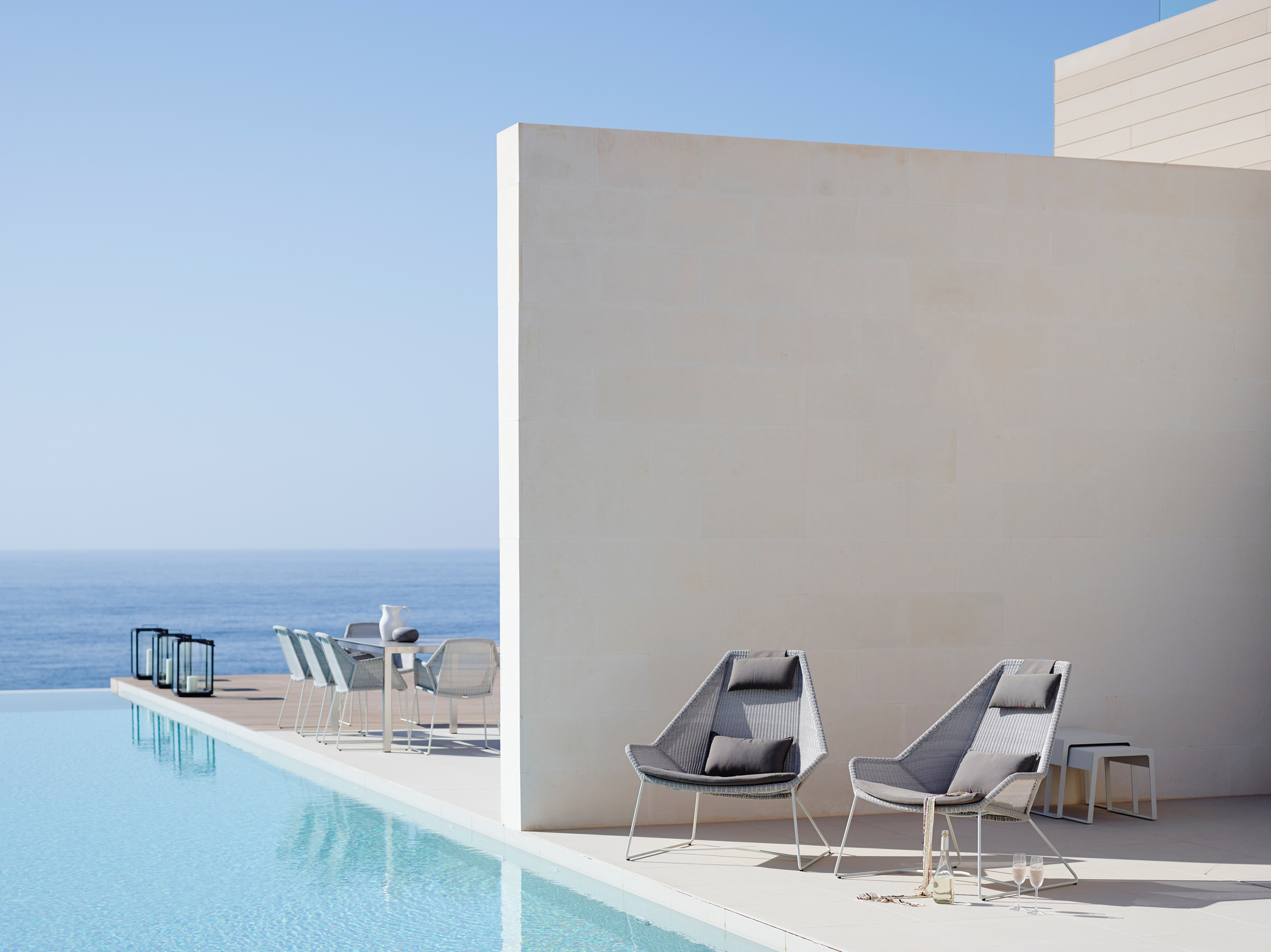 Zwei Cane-Line Breeze Highbacksessel aus Rattan am Pool mit Meerblick. Outdoor Möbel.