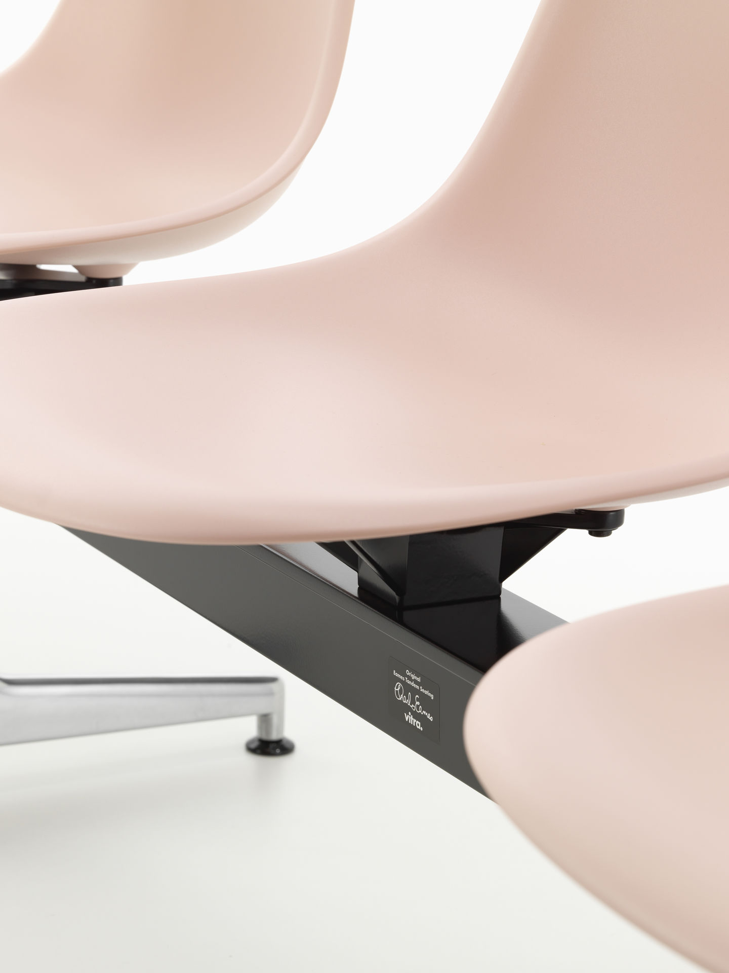 Detailaufnahme des Eames Plastic Side Chair RE auf Traverse von Vitra, Sitzschalen in zartem Rosa.