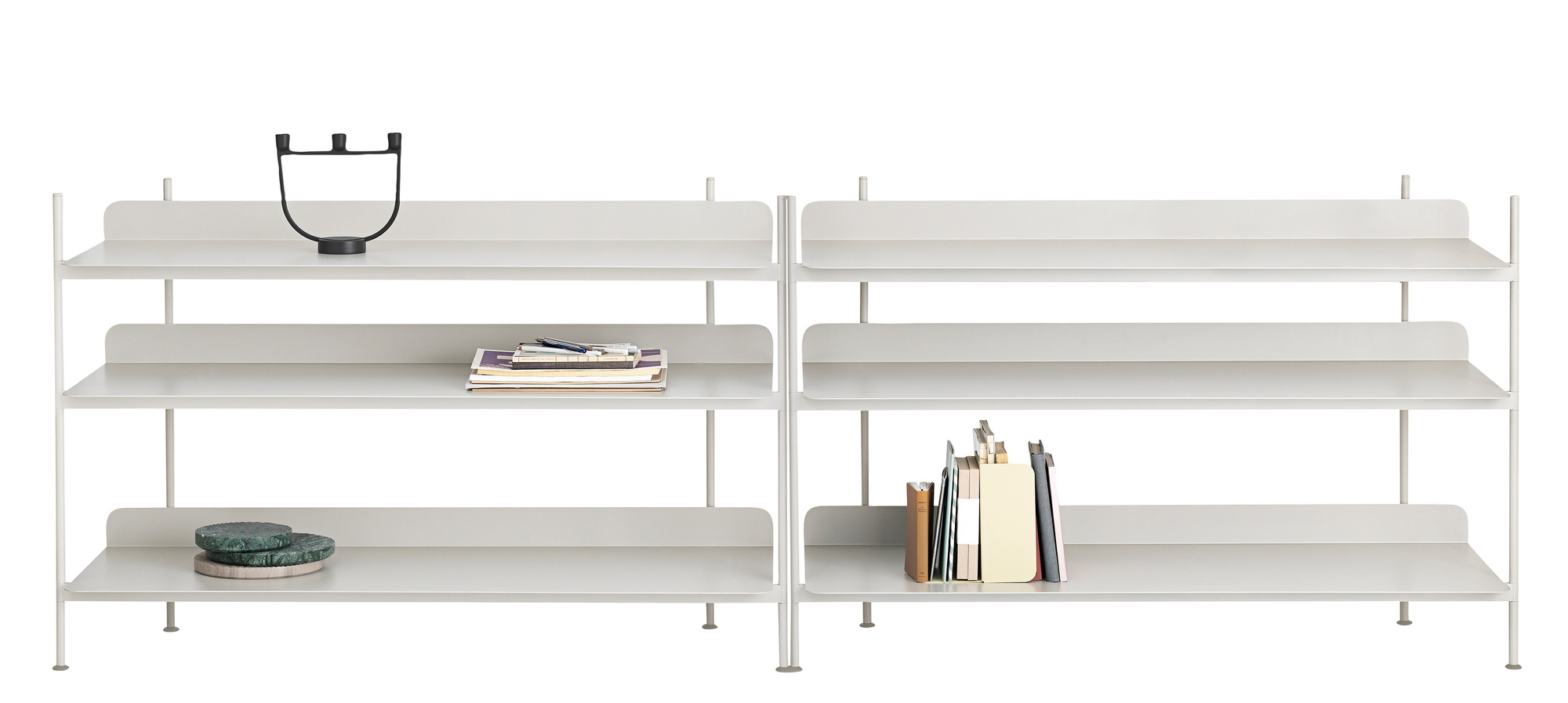 Helles Muuto Compile Regalsystem mit verschiedenen Höhen, ausgestattet mit Büchern, Kerzenständer und Dekoration.