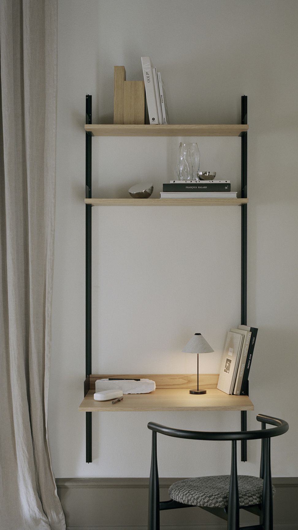 Nahaufnahme der Brolly Tischleuchte von New Works auf einem minimalistischen Holzschreibtisch.