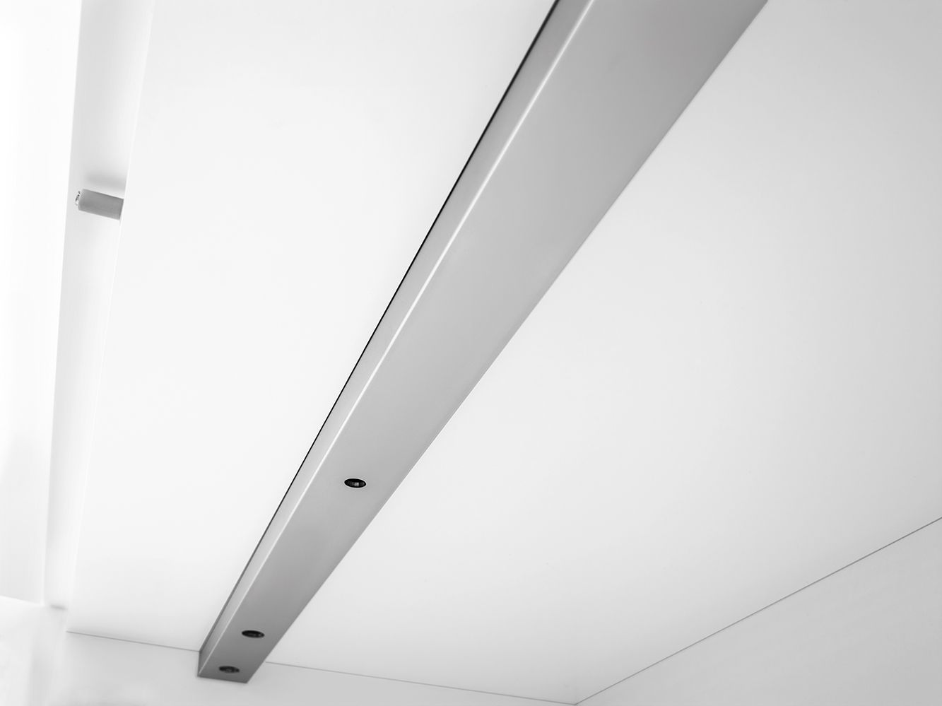 Detailaufnahme des Nex Pur Box TV-Lowboards von Piure mit Medienklappe in Weiß und silberner Akzentleiste.