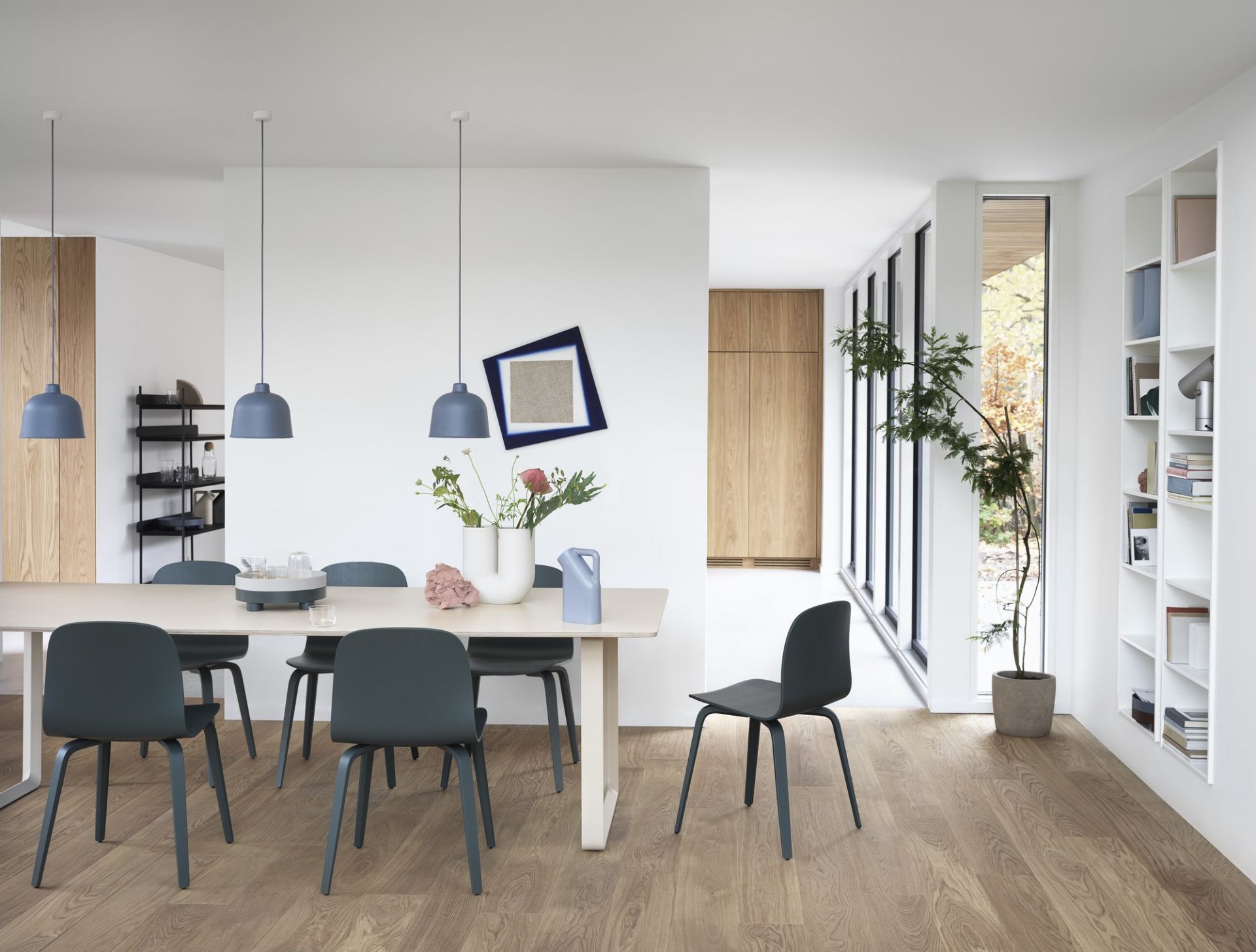Heller Essbereich mit Esstisch, grauen Stühlen, blauen Pendelleuchten und modernem Holzfußboden für ein stilvolles Zuhause.