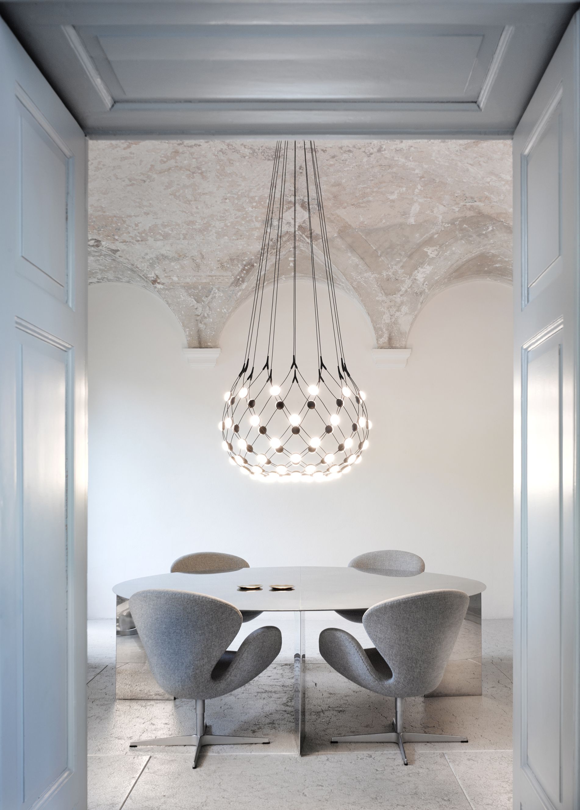 Luceplan D86 Mesh Deckenleuchte über Esstisch mit grauen Stühlen in modernem Interieur.