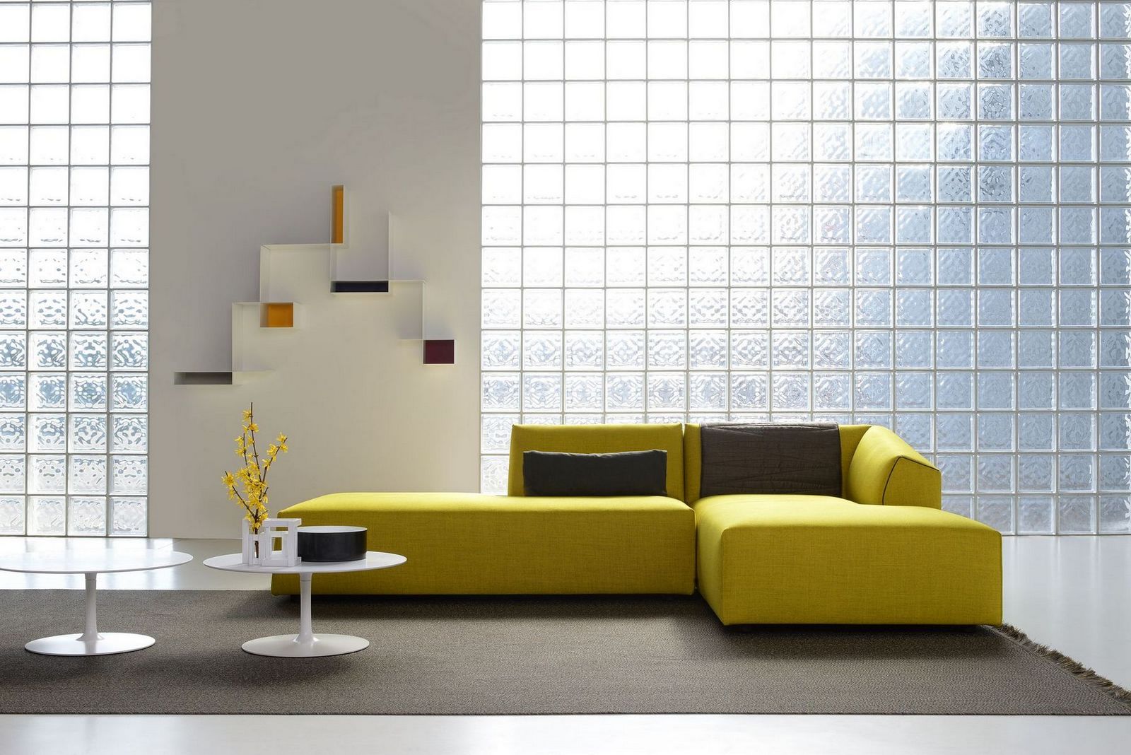 Gelber Flow Low Table Couchtisch von MDF Italia im modernen Wohnzimmer mit Glasbausteinwand.