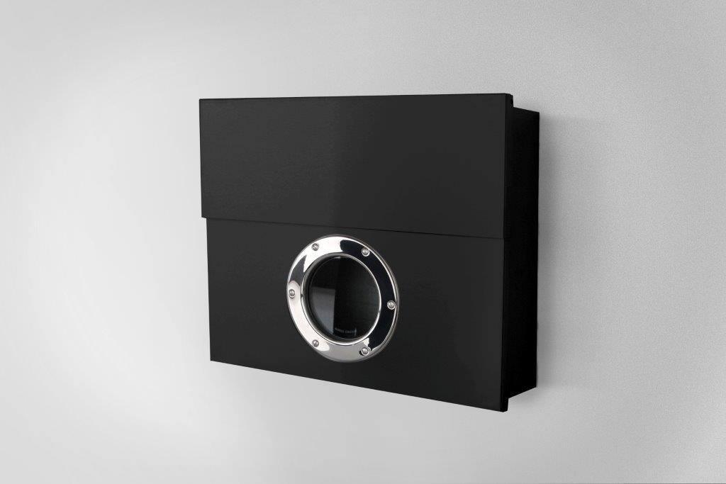 Schwarzer Briefkasten mit Bullauge aus Edelstahl an einer weißen Wand, moderne Hauspostkasten-Design.
