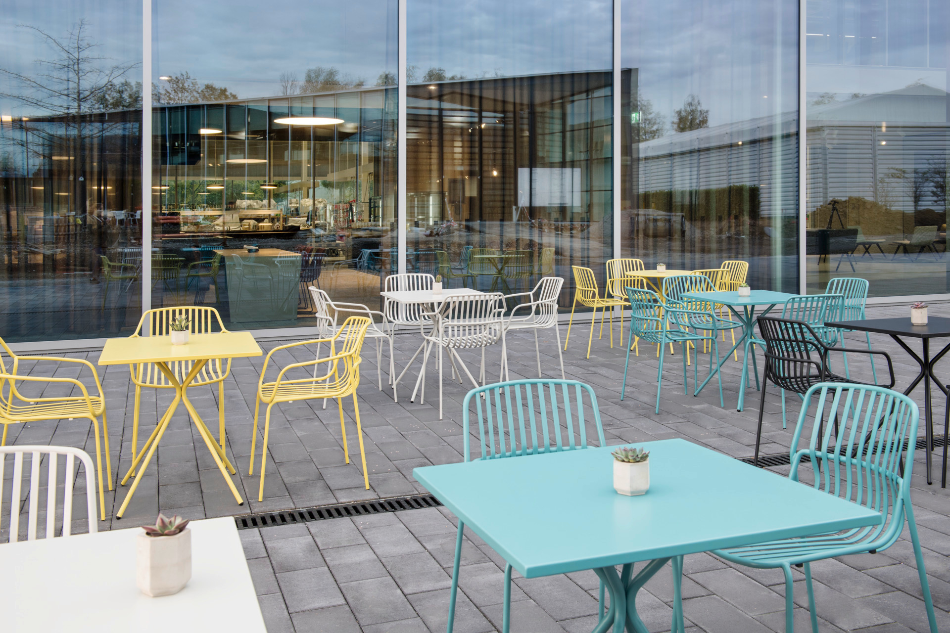 Bunte Crona Steel Stapelstühle von Brunner für den Außenbereich auf einer Terrasse. Outdoor Möbel.