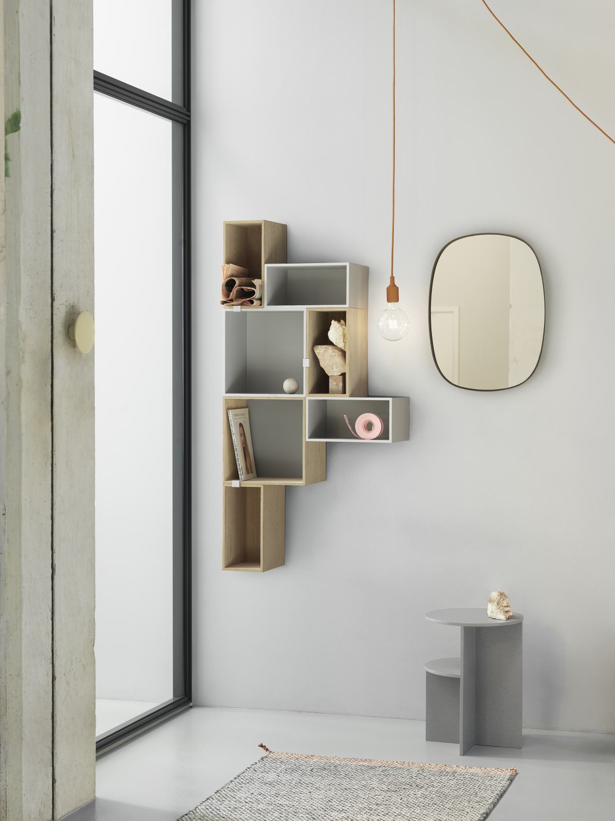 Muuto Stacked Storage System 2.0: Modulares Regalsystem in Eiche und Grau an einer weißen Wand.